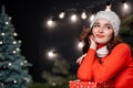 Pretty woman with hand near face poses to camera while looking away dreamy. Red sweater on a nice girl Royalty Free Stock Photo