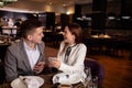 Pretty woman happily tell interesting story to boyfriend in restaurant Royalty Free Stock Photo