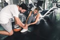 Pretty Woman Having Injury During Exercise in Gym While Her Couple Taking First Aid, Accident and Sport Fitness Concept