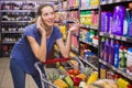 Pretty woman having a phone call and pushing trolley Royalty Free Stock Photo