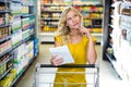 Pretty woman having phone call and pushing trolley Royalty Free Stock Photo