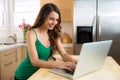 Pretty woman on her laptop looking up recipe to cook in the kitchen Royalty Free Stock Photo