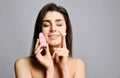 Pretty woman hold pink face exfoliator brush silicone cleansing device for sensitive normal skin and cream. She relishes softness