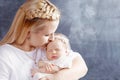 Pretty woman holding a newborn baby girl in her arms. Happy mother kissing her slipping newborn baby.  Happy family concept. Close Royalty Free Stock Photo