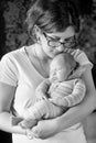 Pretty woman holding a newborn baby in her arms. Black and white. Royalty Free Stock Photo