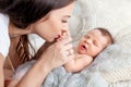 Pretty woman holding a newborn baby in her arms. Happy mother and her slipping newborn baby in the bed Royalty Free Stock Photo