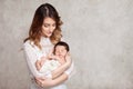 Pretty woman holding a newborn baby in her arms. Portrait of mother and little baby. Copy space Royalty Free Stock Photo