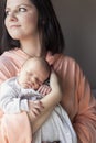 Pretty woman holding a newborn baby in her arms