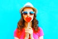 Pretty woman kissing red lollipop shape of a heart