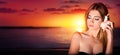 Pretty woman listen to the seashell to the sunset Royalty Free Stock Photo