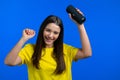 Pretty woman listening to music by wireless portable speaker - modern sound system. Teenager dancing, enjoying on blue Royalty Free Stock Photo