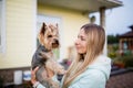 Pretty woman with long blonde hair holding small dog yorkshire terrier outdoor Royalty Free Stock Photo