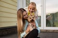 Pretty woman with long blonde hair holding small dog yorkshire terrier outdoor, next sitting little girl. Happy Mother and Royalty Free Stock Photo