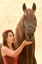 Pretty woman looking at her black horse Royalty Free Stock Photo