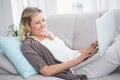 Pretty woman lying on sofa using her laptop Royalty Free Stock Photo