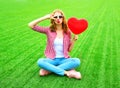 Pretty woman makes an air kiss with red balloon in the shape of a heart Royalty Free Stock Photo