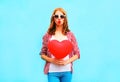 Pretty woman makes an air kiss with red balloon in the shape Royalty Free Stock Photo