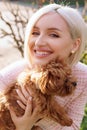 Pretty woman with a MALTIPOO dog. Adorable toy MALTIPOO puppy in arms of its loving owner. Small adorable doggy with funny curly