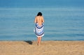 Pretty woman with a mandala round beach tapestry in the seaside.