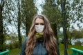 Pretty woman in medicine mask outdoors
