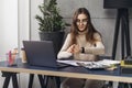 Pretty woman millennial using laptop while sitting at desk. Young businesswoman sitting in office, working on computer. Online Royalty Free Stock Photo
