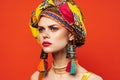 pretty woman in multicolored turban attractive look Jewelry red background Royalty Free Stock Photo