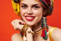 pretty woman in multicolored turban attractive look Jewelry red background Royalty Free Stock Photo