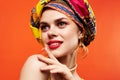 pretty woman in multicolored turban attractive look Jewelry red background Royalty Free Stock Photo