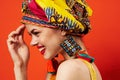 pretty woman in multicolored turban attractive look Jewelry red background Royalty Free Stock Photo