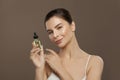 Pretty woman with natural oil bottle. Facial treatment and alternative medicine concept