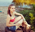 Pretty woman at nature, sitting on stump