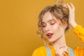 Pretty woman with orange eye shadow makeup on yellow background