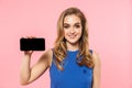 Pretty woman posing isolated over pink wall background using mobile phone showing empty display Royalty Free Stock Photo