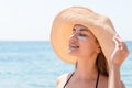 Pretty woman protects her skin on face with sunblock at the beach