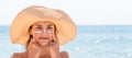 Pretty woman protects her skin on face with sunblock at the beach