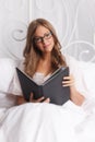 Pretty woman reading in the bed Royalty Free Stock Photo