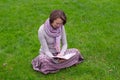 Pretty woman reading a book on a grass Royalty Free Stock Photo