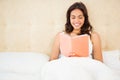 Pretty woman reading book in her bed Royalty Free Stock Photo