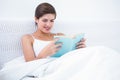 Pretty woman reading a book in her bed Royalty Free Stock Photo