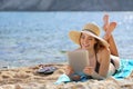 Pretty woman reading a tablet reader on the beach on vacations
