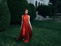 Pretty woman red dress walking luxury model outdoors Royalty Free Stock Photo