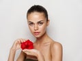 pretty woman with red flower in her hands naked shoulders clear skin model Royalty Free Stock Photo