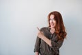 Pretty woman with red hair gesturing with fingers and showing away Royalty Free Stock Photo