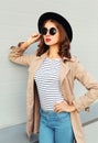 Pretty woman with red lips wearing fashion black hat sunglasses coat over grey Royalty Free Stock Photo