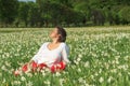 Pretty woman relaxing in white flowers field