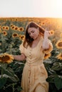 Pretty woman in retro dress posing in sunflowers field. Yellow colors, warm toning. Vintage timeless fashion, amazing Royalty Free Stock Photo