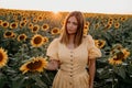 Pretty woman in retro dress posing in sunflowers field. Yellow colors, warm toning. Vintage timeless fashion, amazing Royalty Free Stock Photo