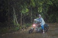 pretty woman riding small enduro motorcycle crossing shallow creek