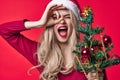 pretty woman in santa claus costume with christmas tree in hands tradition holiday isolated background Royalty Free Stock Photo