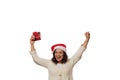 Pretty woman in santa hat clenching her fists, rejoicing at christmas gift in her hands, isolated on white background Royalty Free Stock Photo